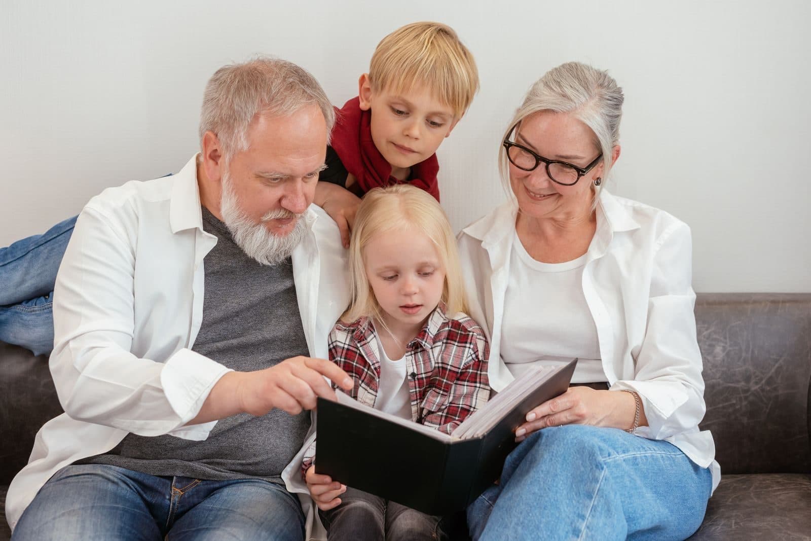 Grandparents looking through a photo album with two young grandchildren